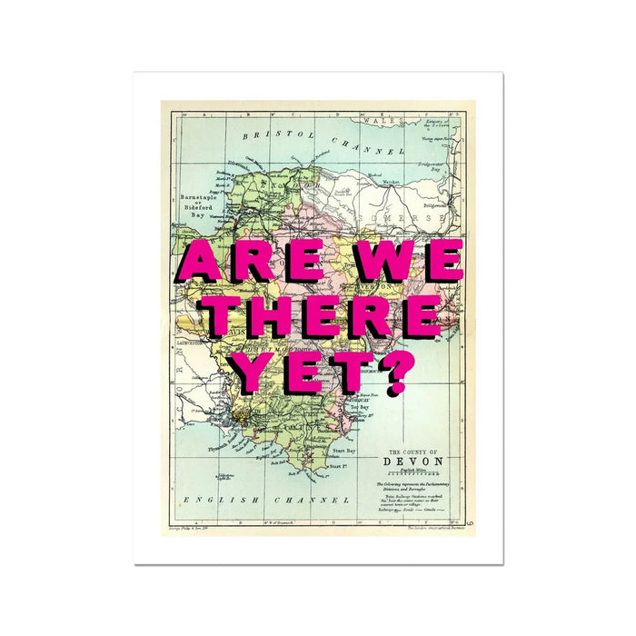 A framed Devon Map print featuring a vintage map of Devon with the playful text 'ARE WE THERE YET?' superimposed on it in pink typography.