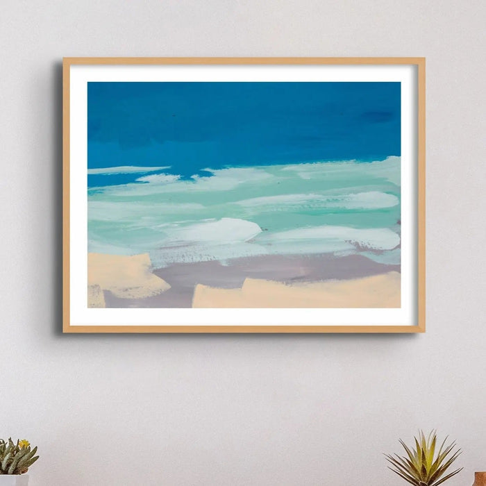 Watercolour coastal painting in blue and sand above a side table - Framed in a black frame