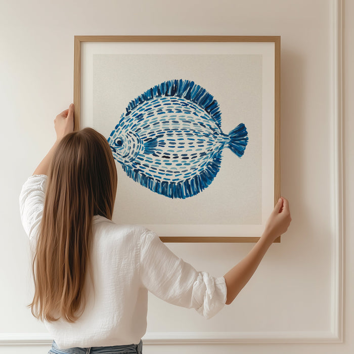 framed fish print being hung on wall in natural wood frame.