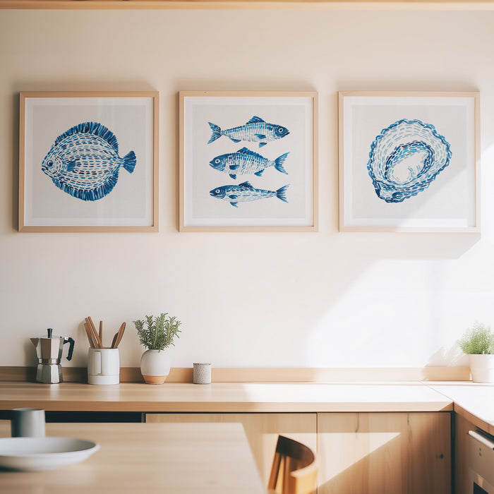Framed artwork of fish and shells on a wall above a kitchen counter.
