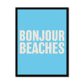 A framed word art print on the wall with a black frame, with the text 'BONJOUR BEACHES' in bold white letters on a blue background.