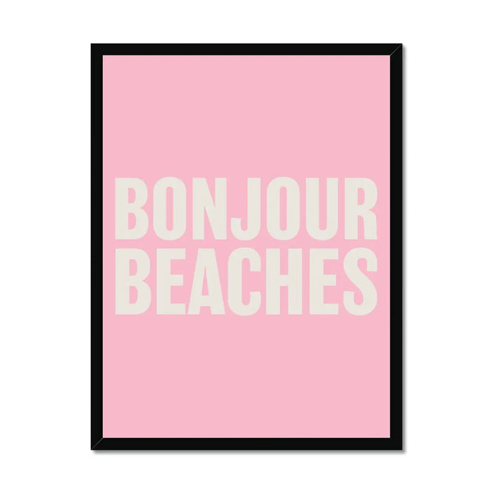 A framed word art print with the text 'BONJOUR BEACHES' in bold, white letters on a pink background, enclosed in a black frame.