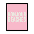 A framed word art print with the text 'BONJOUR BEACHES' in bold, white letters on a pink background, enclosed in a black frame.