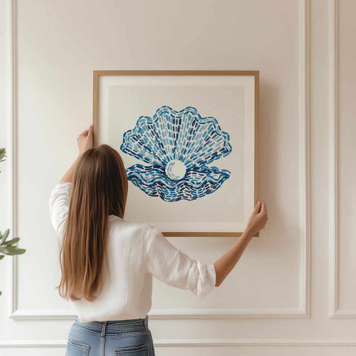 a framed clam shell print being hung on wall in living room
