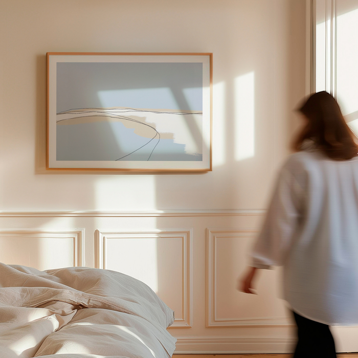 Woman walking in a bedroom with a large     minimal coastal artwork inspired by sea and shoreline
