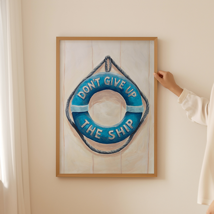 Framed artwork of a life buoy with 'Don't Give Up The Ship' text on a wall.