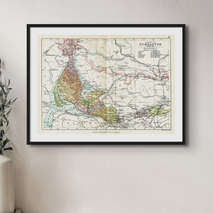 A framed map print of Dumbarton and Loch Lomond, with surrounding areas, on wall next to house plant.