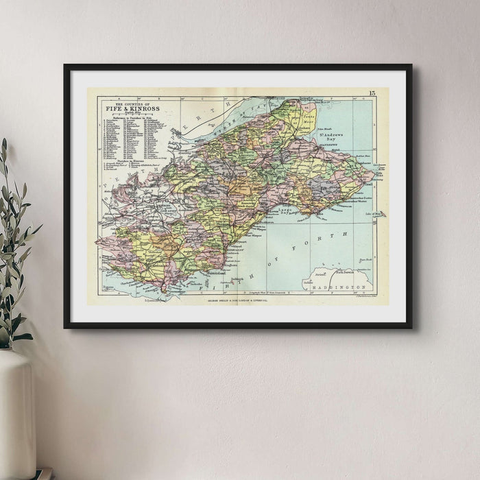 A framed print of a vintage map depicting the regions of Fife and Kinross with various place names and boundaries highlighted in different colours.