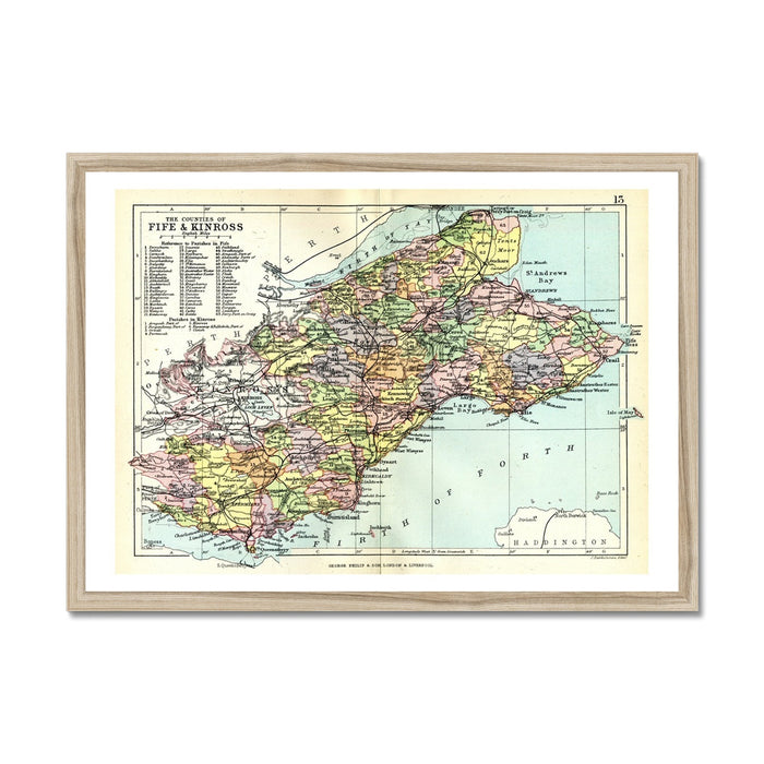 Framed vintage map print of Fife and Kinross, Scotland, on wall next to house plant. Featuring coloured cartography on a textured paper surface, enclosed in a wood frame.
