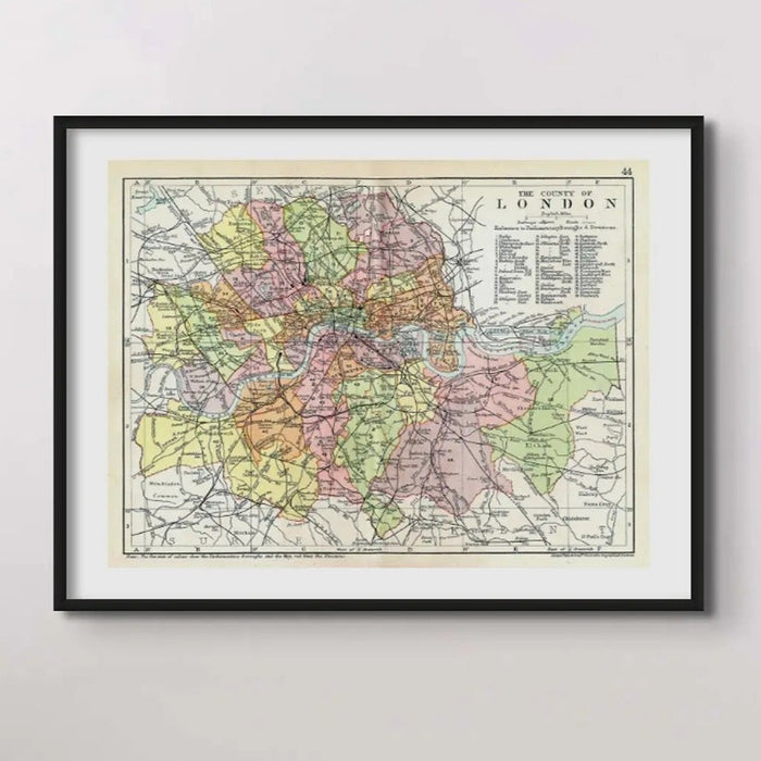 Framed vintage map print of London featuring a detailed, multi-coloured map enclosed in a black frame.