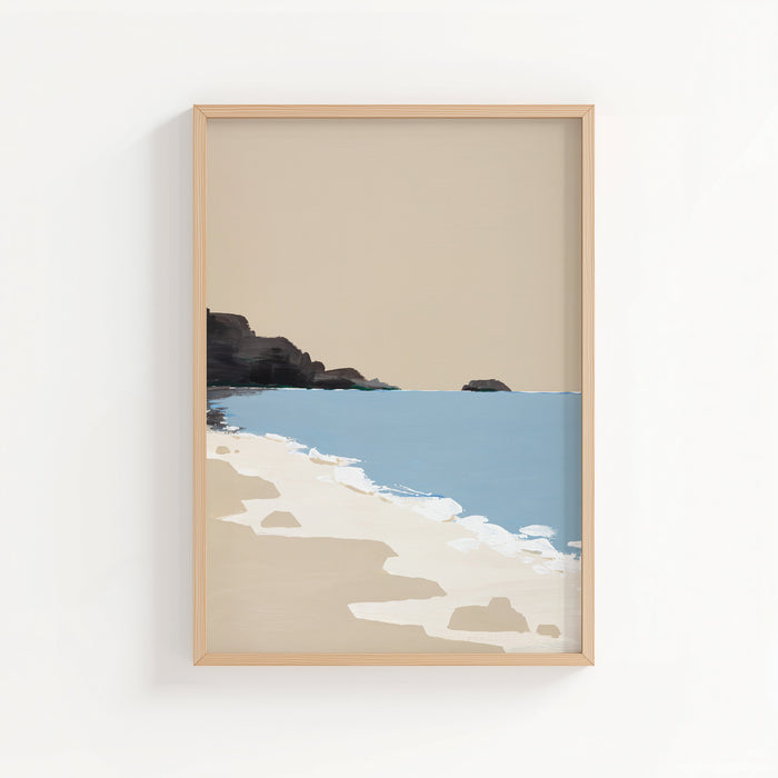 Framed artwork of a beach scene with rocks and water on a white wall