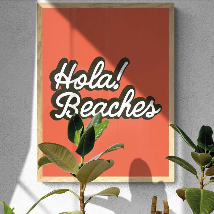 A framed orange art print with the text 'Hola Beaches' in a white and black font.