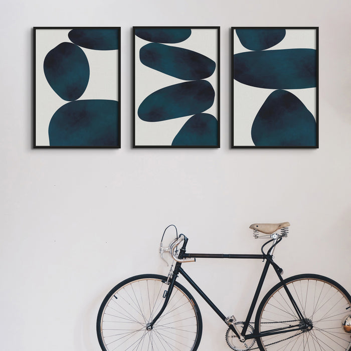Set of three blue abstract art prints in hallway.