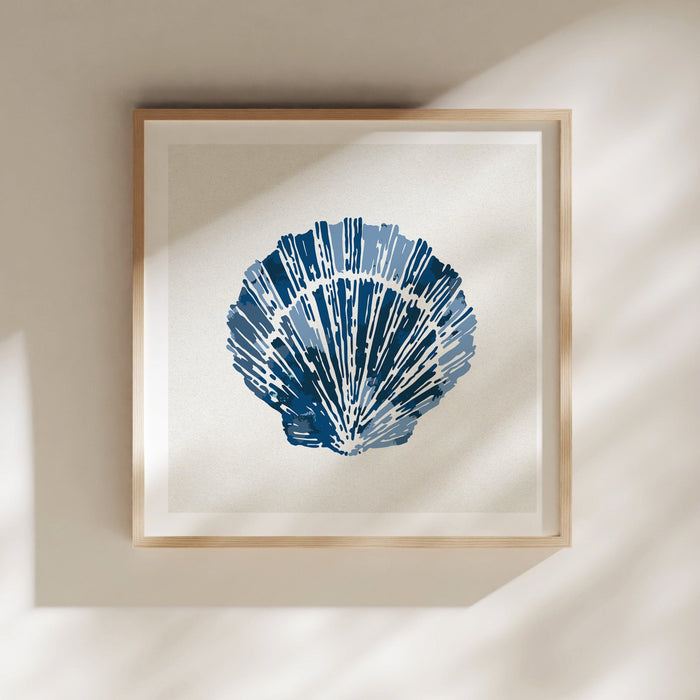 Framed indigo scallop shell wall art in natural wood frame, styled on a light neutral wall with soft shadows.