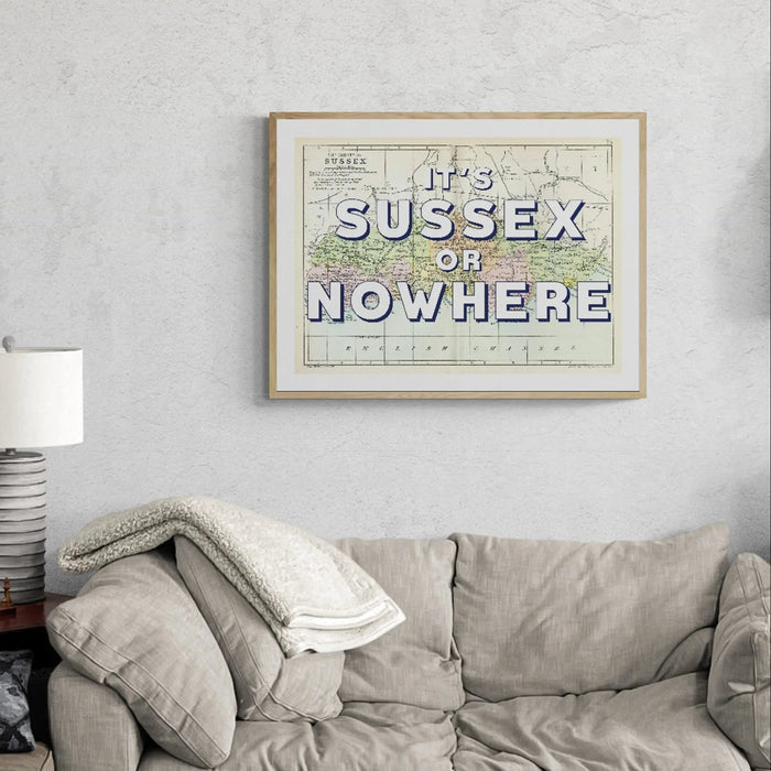 A vintage Sussex map print with the text 'It's Sussex or Nowhere' overlayed on a map background, in the living room above the sofa.