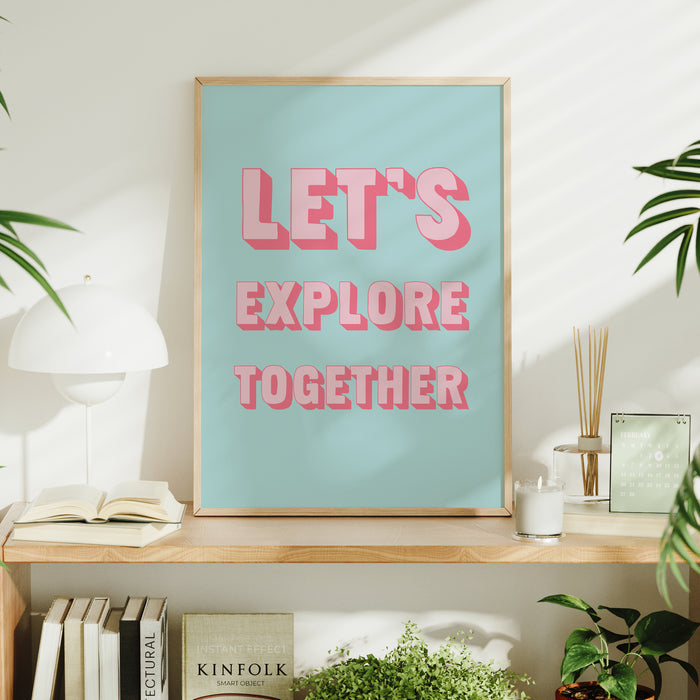 Framed poster with 'LET'S EXPLORE TOGETHER' text on a shelf with books and plants.