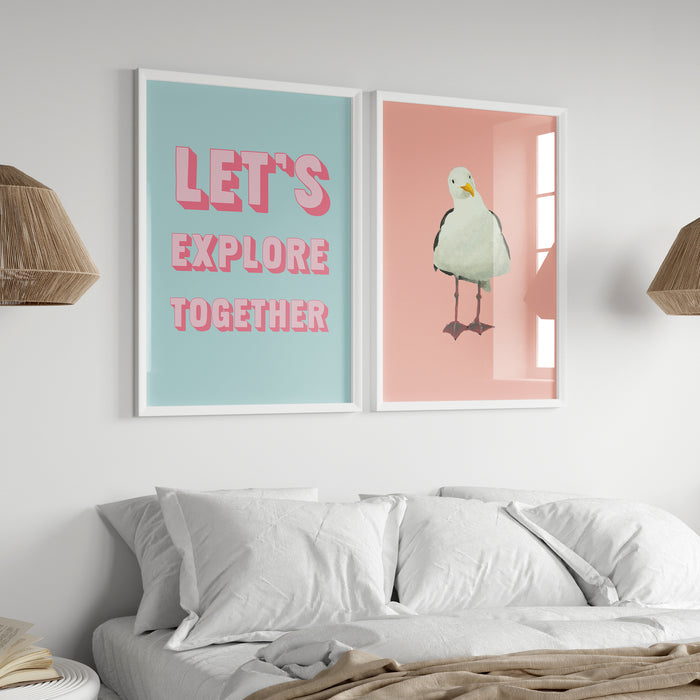 Two framed prints on a wall above a bed, one with 'LET'S EXPLORE TOGETHER' text and the other with a bird illustration.