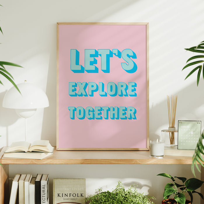 Framed coastal typography print with 'Let's Explore Together' text on a shelf with decor items.