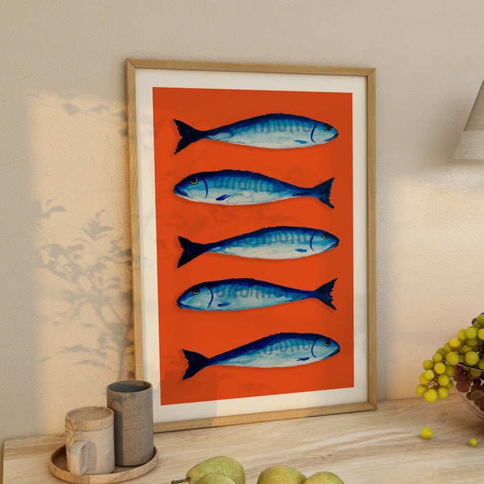 Framed art print of blue mackerel fish on an orange background in a kitchen.