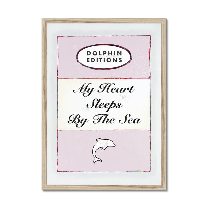 Framed art piece featuring a vintage book cover print with the title 'My Heart Sleeps By The Sea' on a pink background.