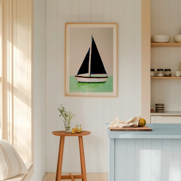 Framed artwork of a sailboat on a wall in a room with a stool and table.