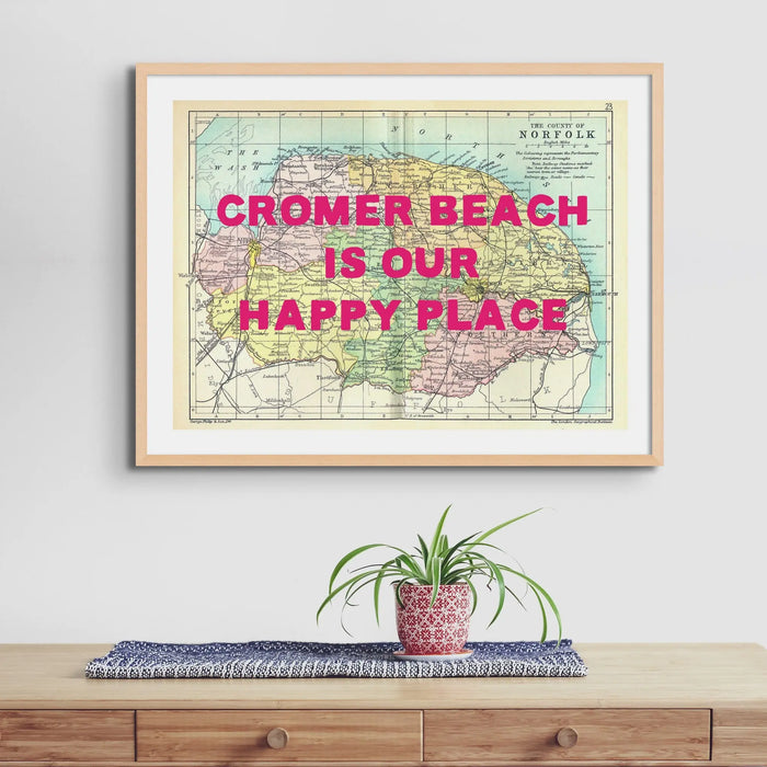 Personalised vintage map print of Norfolk with navy font framed above coastal sideboard.