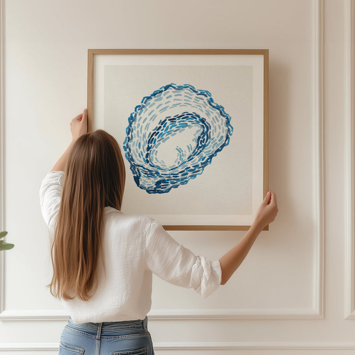 Oyster shell coastal wall art featuring layered blue brushstrokes on a soft neutral background. Framed and being hung in living room