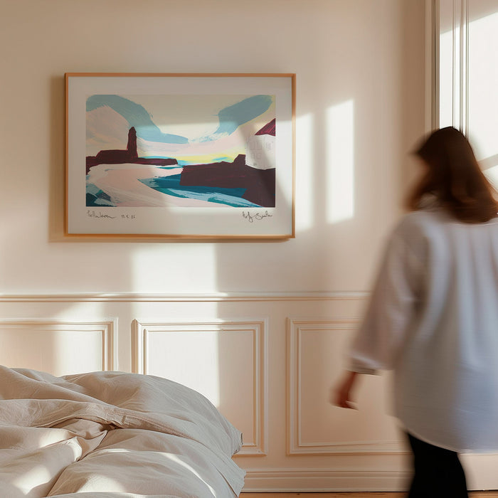 A framed abstract landscape art print hangs on a cream-colored wall in a sunlit bedroom. A woman in a white shirt walks past the window on the right, and a bed with rumpled white bedding is visible in the foreground.