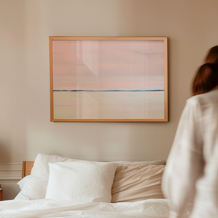 Pink seascape painting with soft horizon line, framed coastal wall art above bed