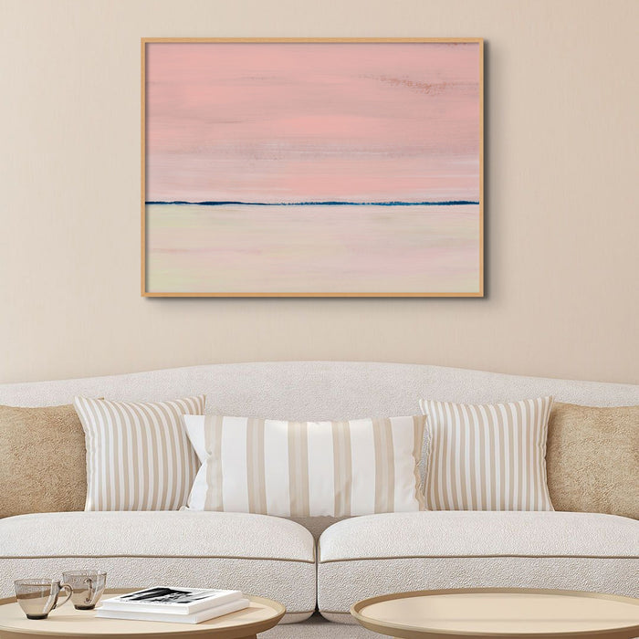 Abstract beach painting featuring horizontal lines with a gradient of pink to blue and rose gold colours, representing a coastal scene above a. white sofa in living room.
