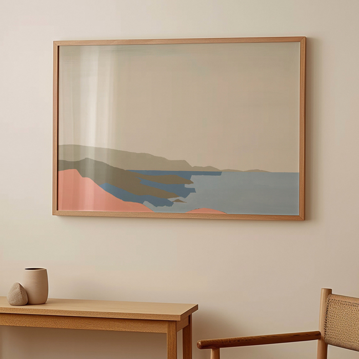 Framed salmon pink abstract artwork on a wall above a wooden table with decorative items.