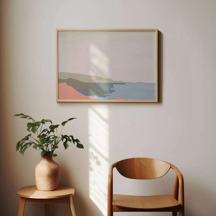 Abstract framed artwork on a wall with a plant and wooden chair below.