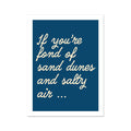 A navy-colored art print with white text that reads: 'If you're fond of sand dunes and salty air...'
