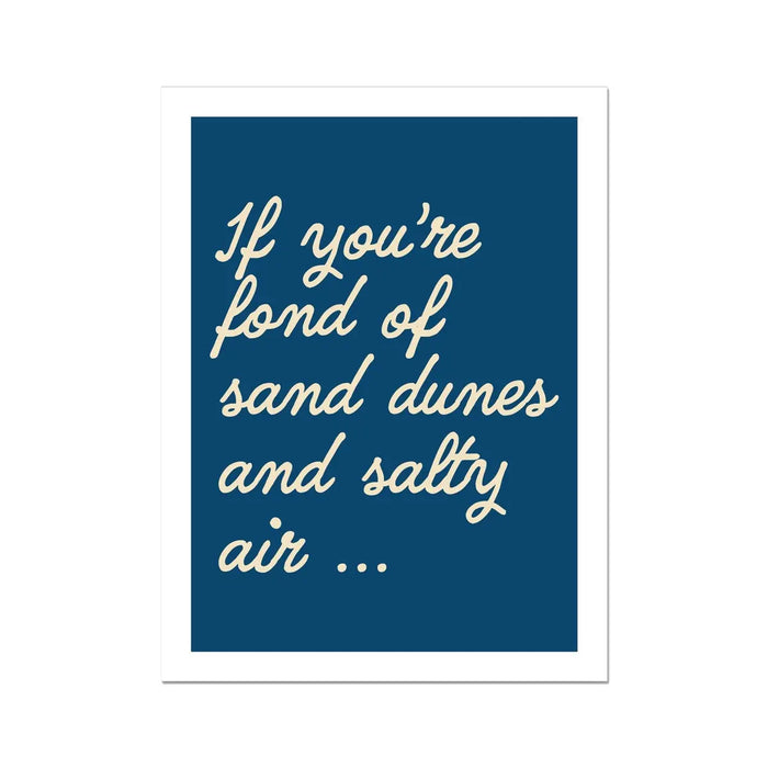 A navy-colored art print with white text that reads: 'If you're fond of sand dunes and salty air...'