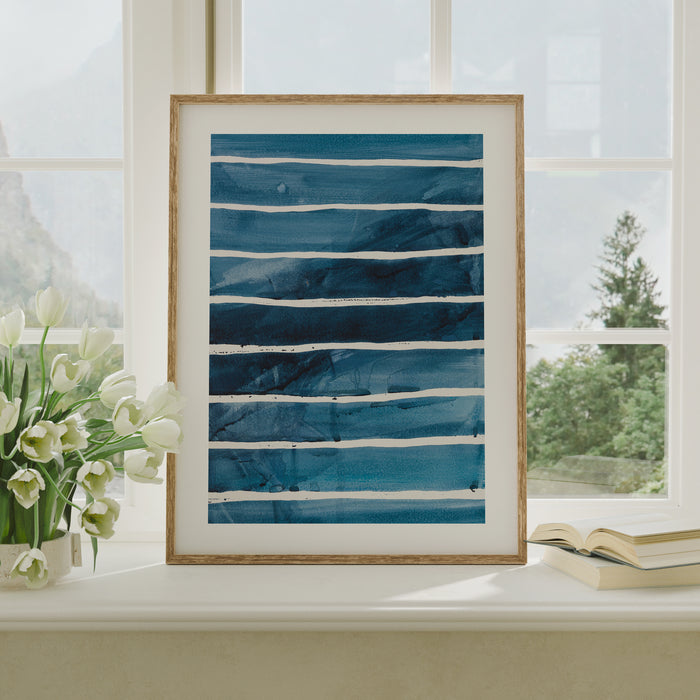A framed abstract line art print of the sea, frame don windowsil.