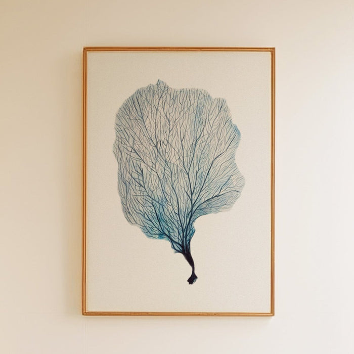 A framed watercolour painting of a blue sea fan coral, with a simple white border and a wooden frame.