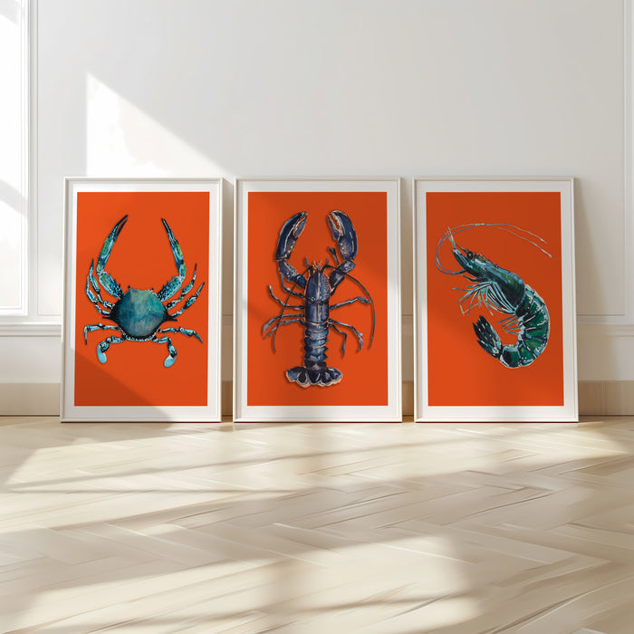 Set of 3 framed artworks of a blue lobster, crab and prawn on an orange background.