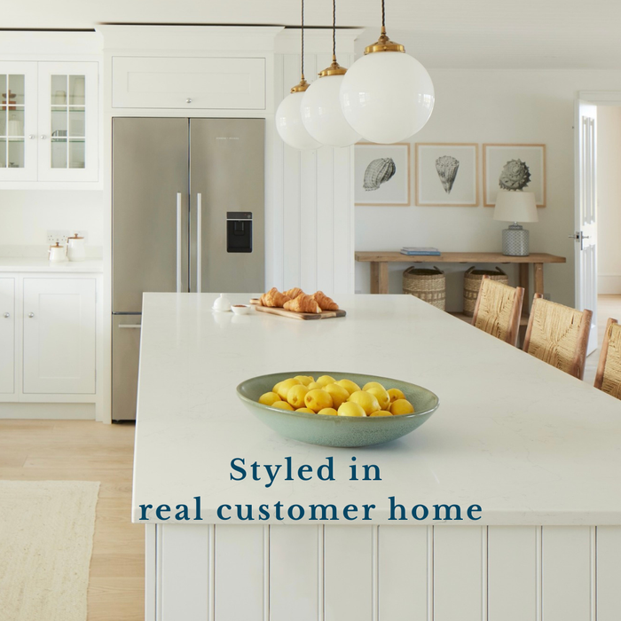 Set of three vintage shell prints in a modern kitchen with a bowl of lemons on a counter, styled in a real customer home.