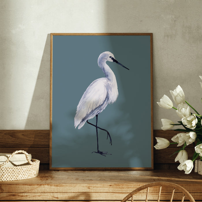 Framed artwork of a white bird on a blue background, displayed on a wooden surface with flowers.