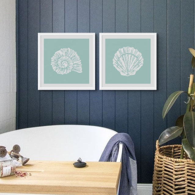 Set of two shell prints in bathroom above freestanding bath