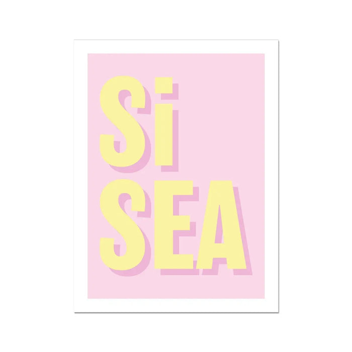 A framed typography art print with the words 'Si Sea' printed in bold yellow letters on a pink background.