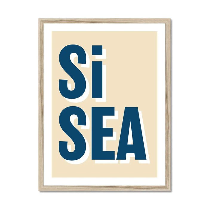 A framed word art print with the text 'Si Sea' in blue letters on a beige background, presented in a simple wooden frame.