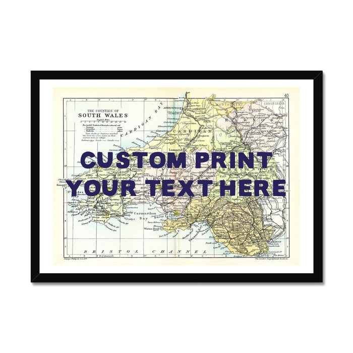 A framed custom map print of South Wales with the text 'CUSTOM PRINT YOUR TEXT HERE' displayed prominently over a vintage map background, indicating a personalised message option.