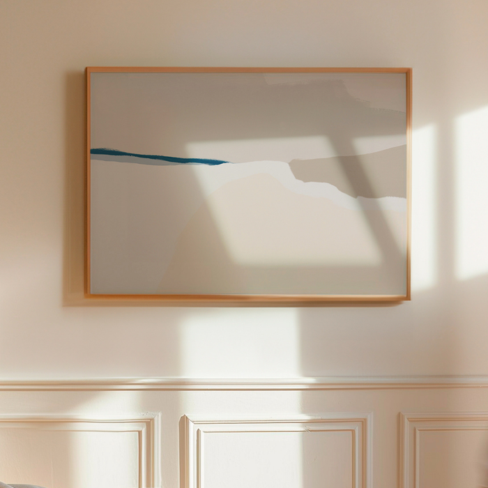 Framed abstract artwork on a wall with sunlight casting shadows.