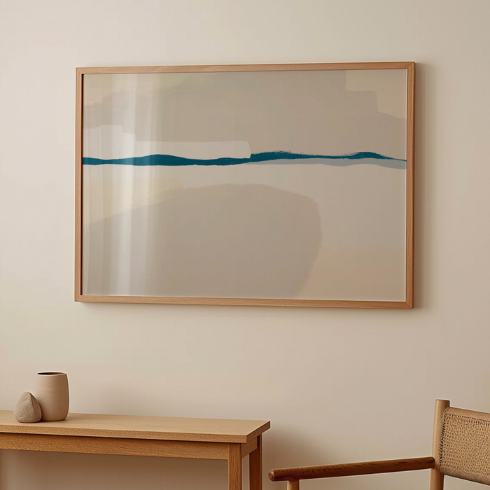 Framed abstract artwork on a wall with a wooden table and chair in the foreground.