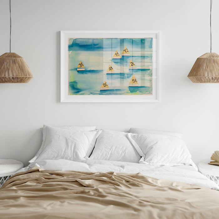 Framed art print featuring a watercolour painting of sailboats with numbered tags, set against a blue and green textured background, above a modern coastal bed.