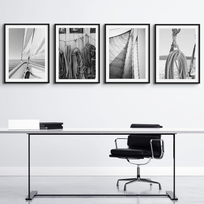 Set of four balck and white photgraphy prints on wall above desk in office.