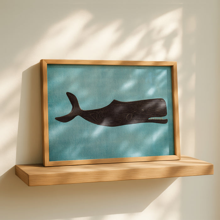 Framed artwork of a whale on a wooden shelf with a light background