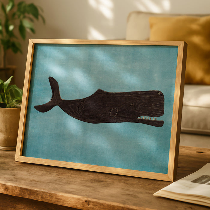 Framed vintage whale painting on a wooden table with a blurred indoor background