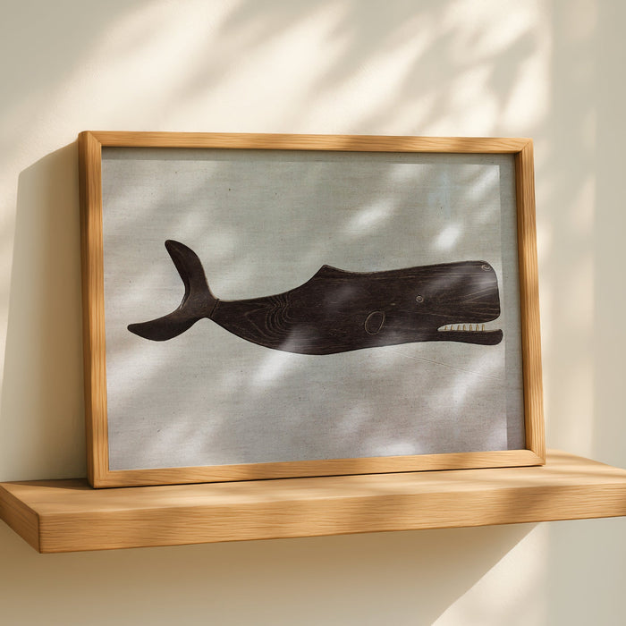 Framed vintage artwork of a whale on a wall with a wooden shelf below